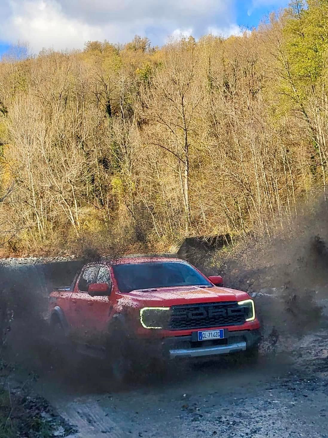 Pick-up rosso in azione su un percorso off-road nel fango