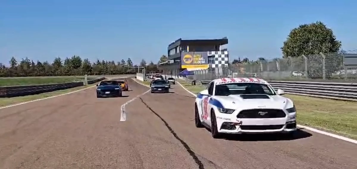 Ford Mustang bianca con livrea Ford Performance Driving University e numero 27 che apre un giro di pista con le altre vetture