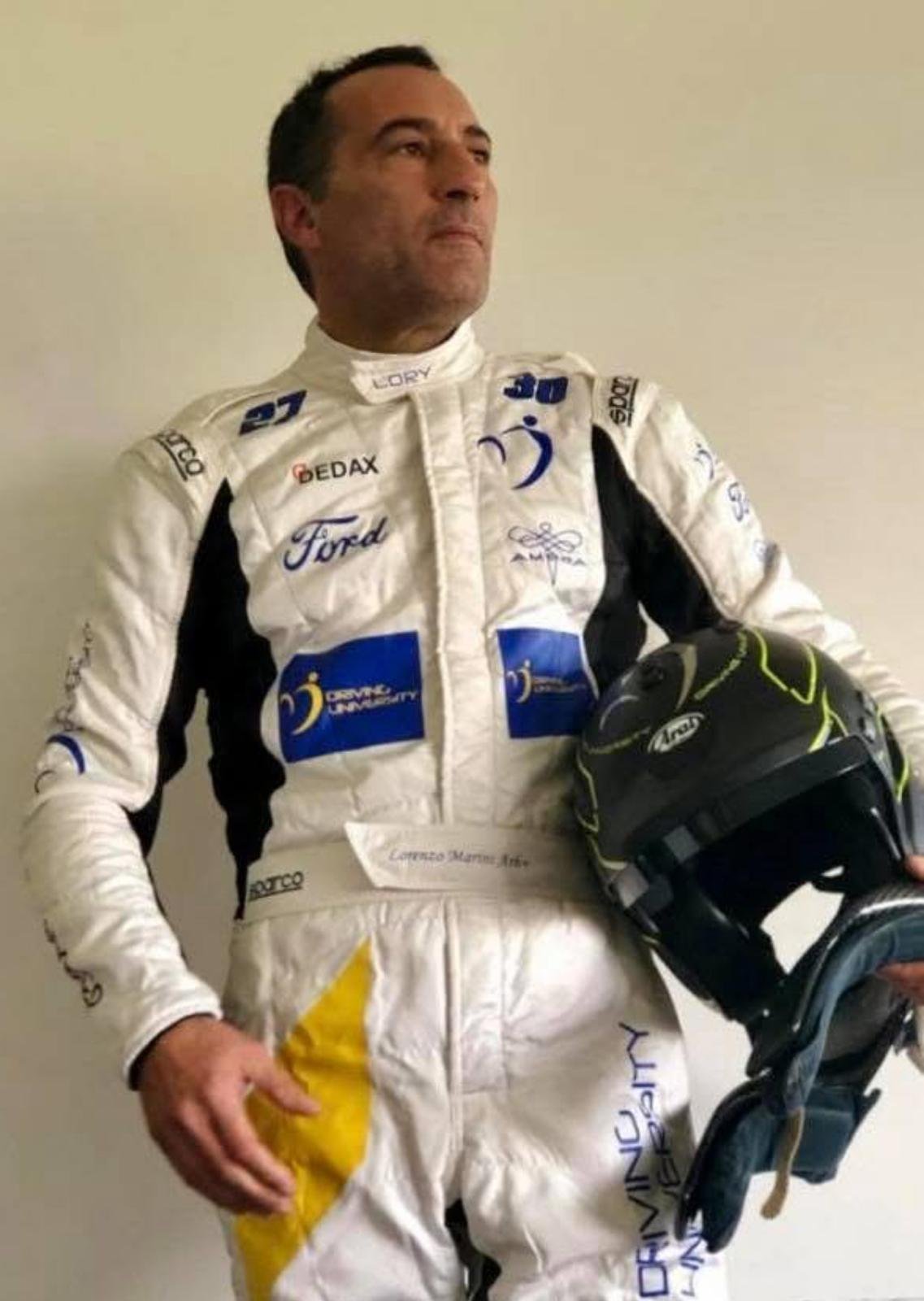 Lorenzo Marini, fondatore di Driving University, in tuta da corsa con casco Arai